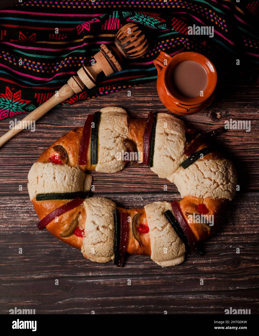 Rosca de reyes or Epiphany cake and clay mug of mexican hot chocolate on a wooden table in Mexico Latin America Stock Photo