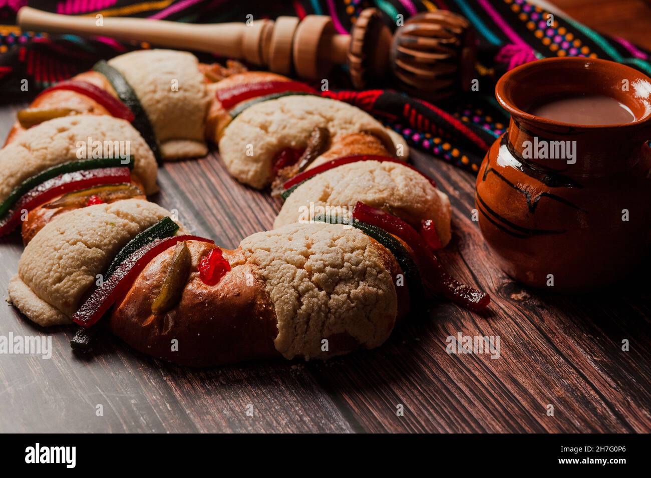 Rosca de reyes or Epiphany cake and clay mug of mexican hot chocolate on a wooden table in Mexico Latin America Stock Photo