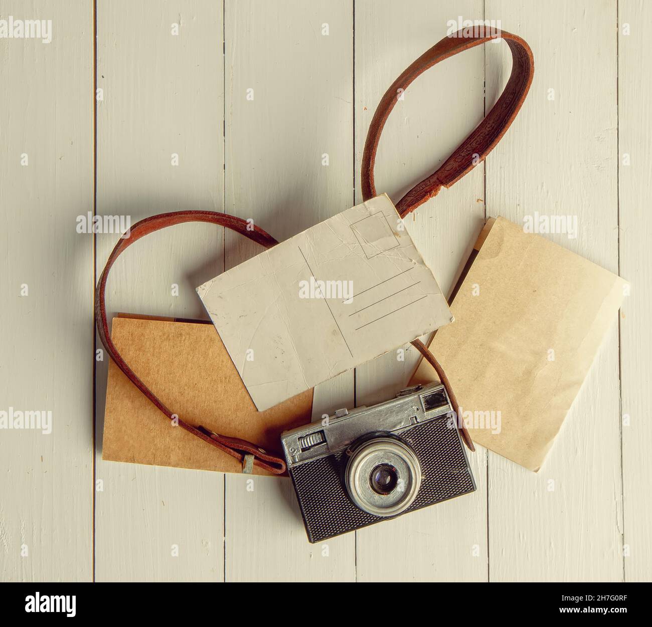 Old film retro camera and several blank backgrounds on rough wooden table Stock Photo