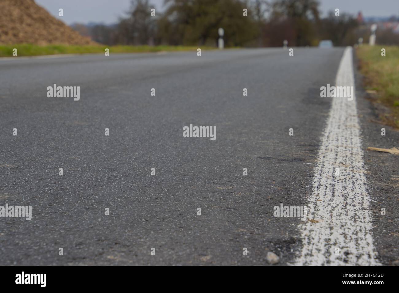 Small country road with white markings on the side with focus on ...