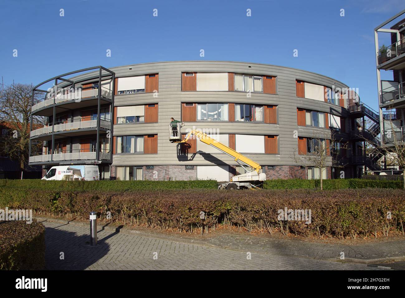 Modern apartments, window cleaner in a bucket of a telescopic boom lift