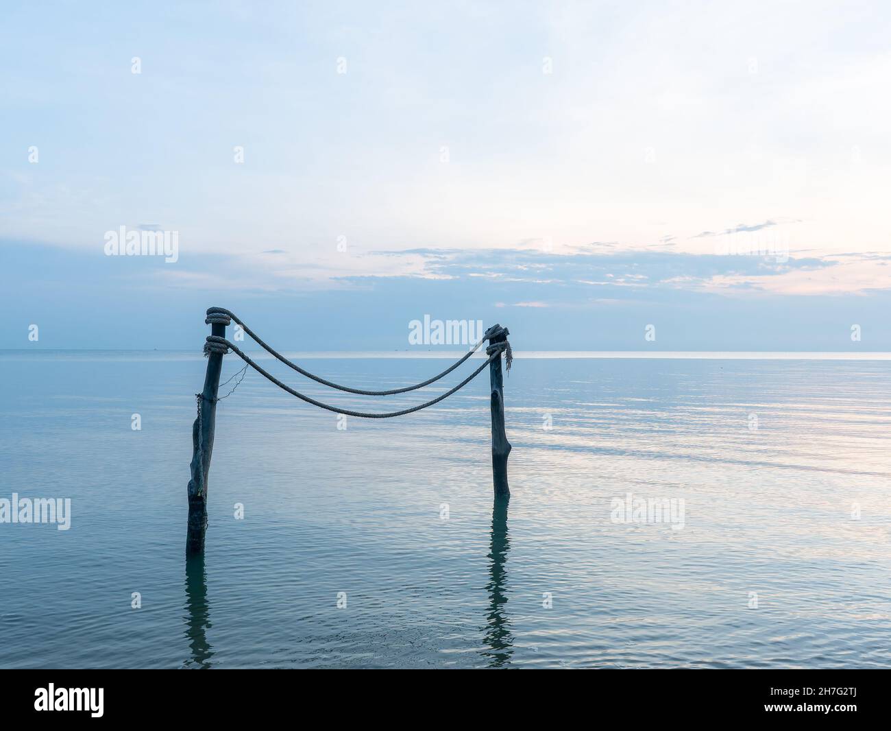 Mooring stakes and rope at dawn on the coast of Surat Thani province in Thailand. Stock Photo