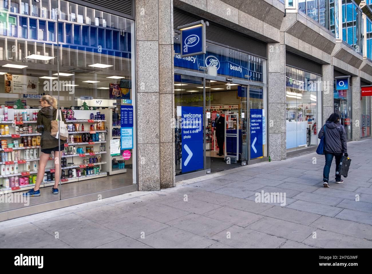 Victoria Westminster London England UK, November 7 2021, Boots Pharmacy Shop Front With A Customer Browsing Products And A Person Walking Past Stock Photo