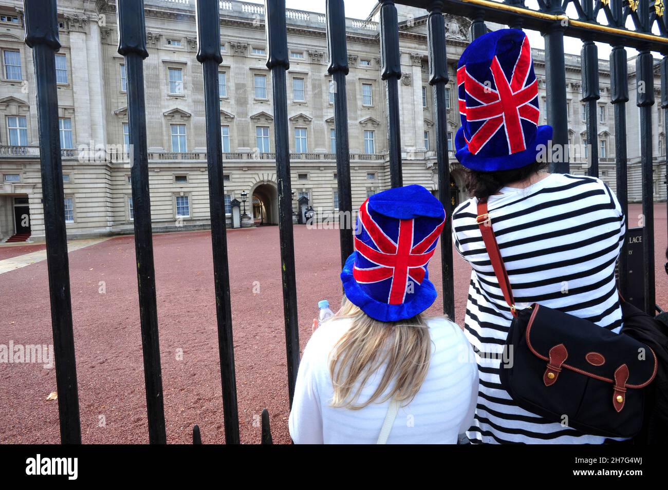 GREAT BRITAIN. LONDON. YOUNG WOMEN IN FRONT OF THE FENCES OF BUCKINGHAM PALACE. THE ROYAL FAMILY IS STILL VERY POPULAR AND HAS A REAL ECONOMIC VALUE. Stock Photo