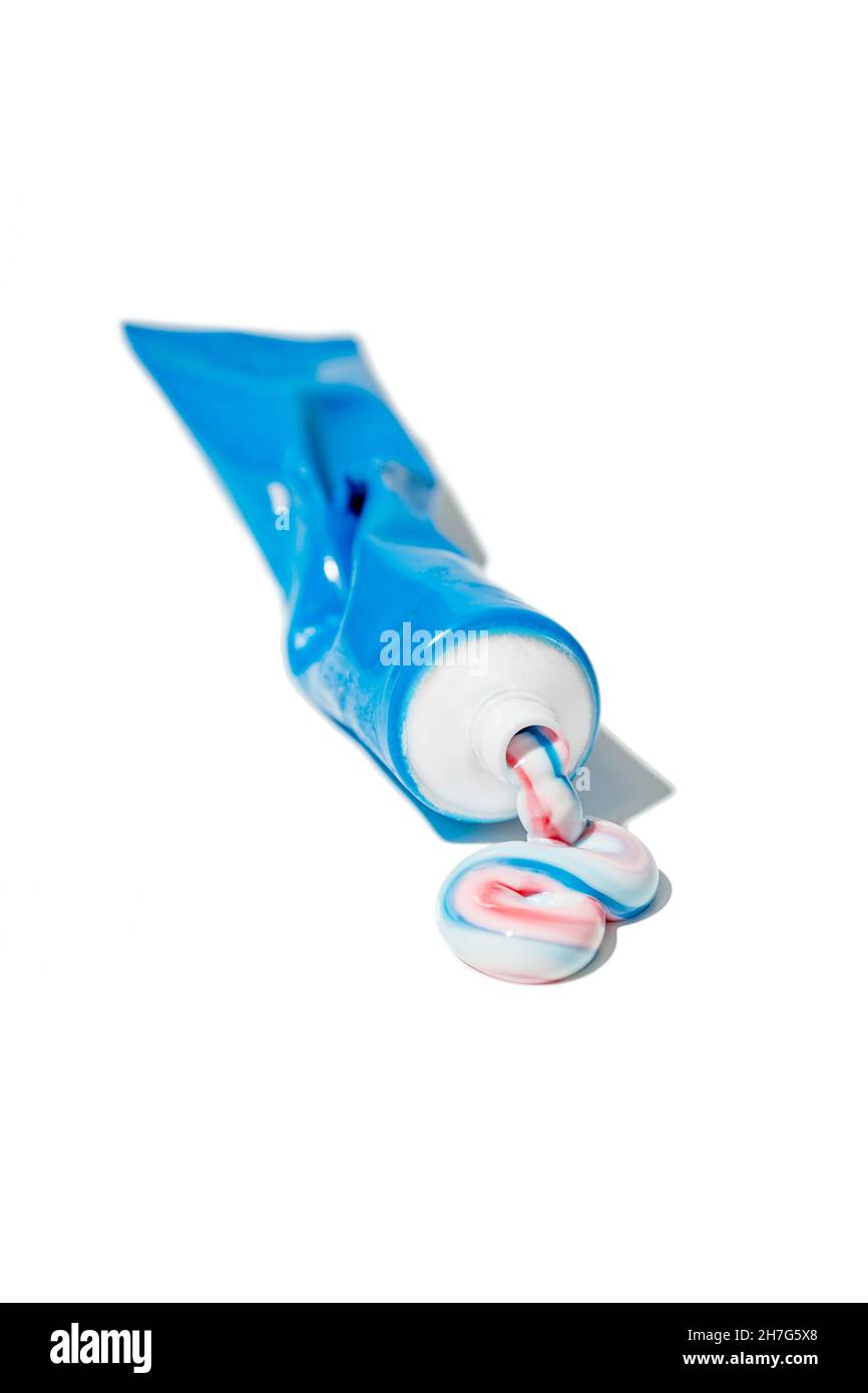Dental blue tube with squeezed out toothpaste in white, red and blue