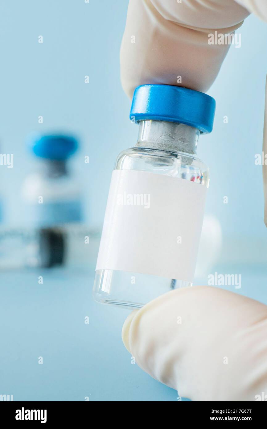 medical vaccine vials or bottles on table top over blue background. blank vial template for label. Vaccination of the population against coronavirus c Stock Photo