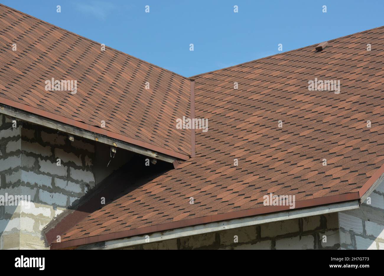 Brown asphalt shingled roof valley leaking problem area with a