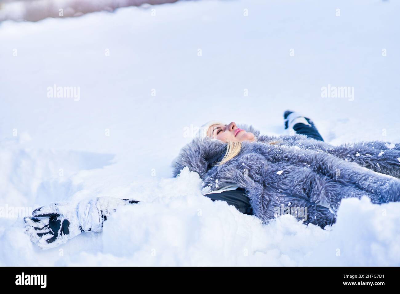 Young nice woman lying on the snow Stock Photo