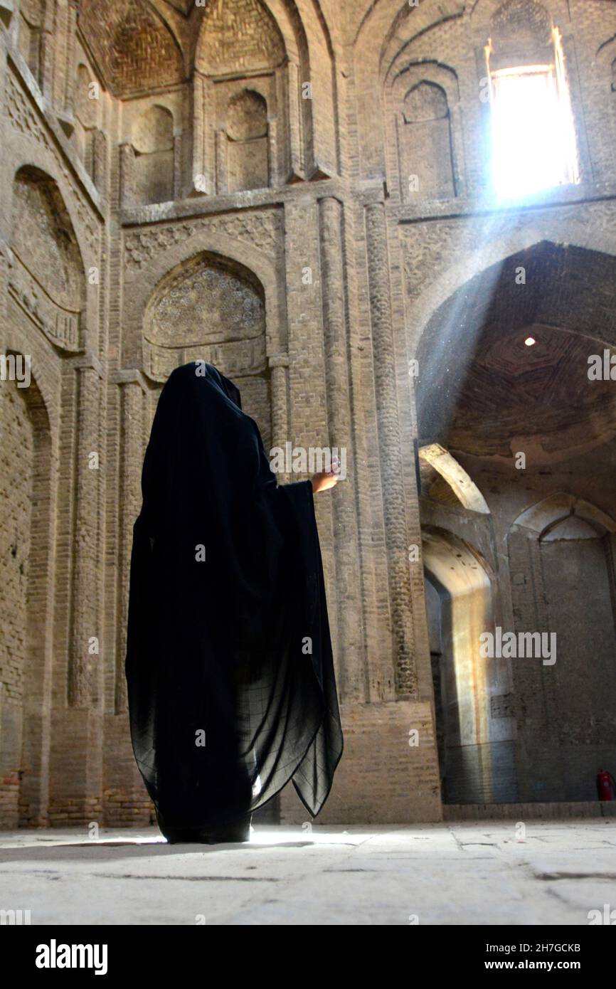 IRAN. ISPAHAN ESFAHAN. WOMAN IN VEIL PRAYING IN THE GREAT MOSQUE, OR FRIDAY'S MOSQUE, BUILT DURING THE XTH CENTURY AND RENOVATED UNDER THE SAFAVIDES P Stock Photo