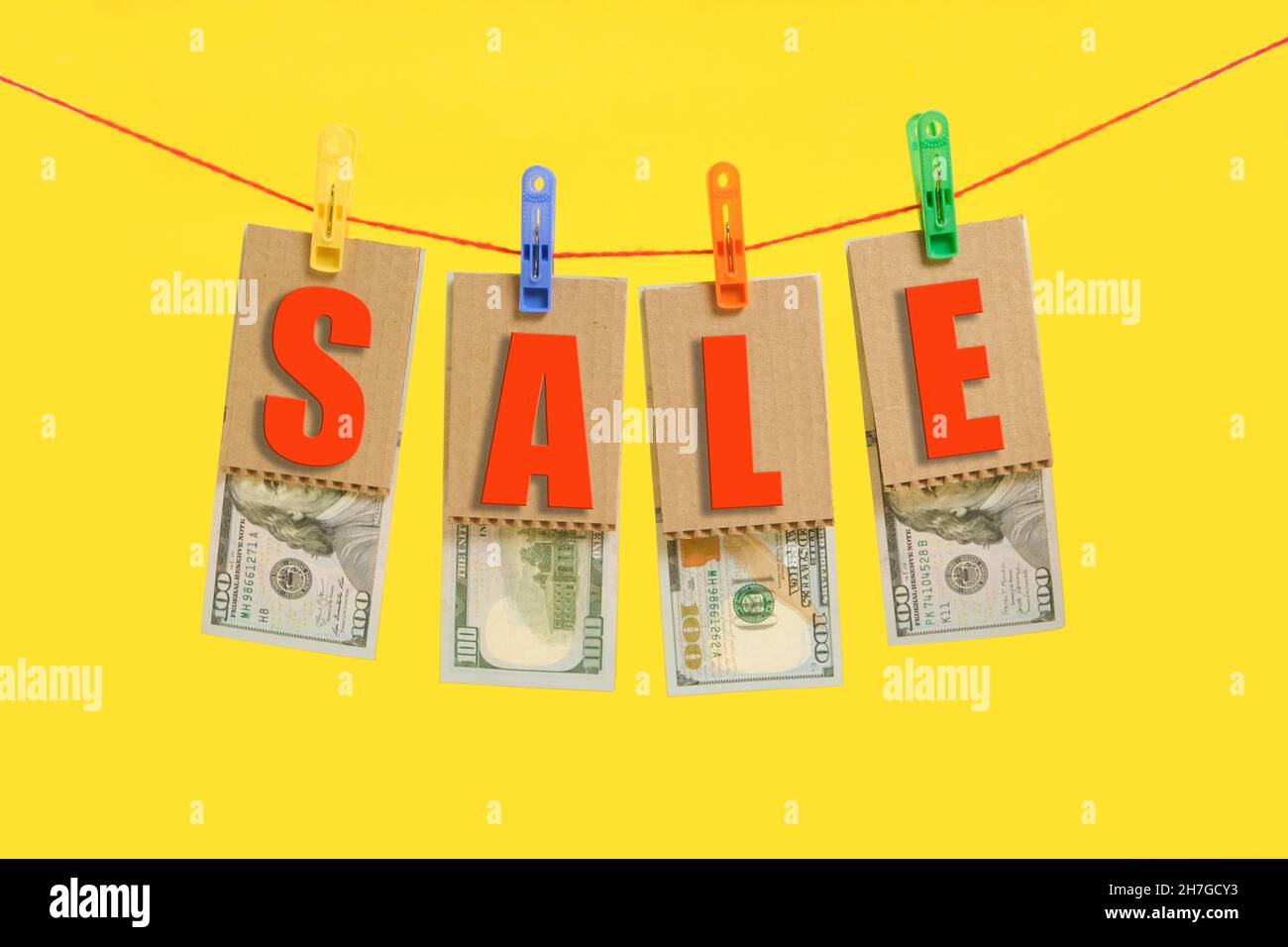 Inscription in red letters sale and hundred dollar bills are hung on