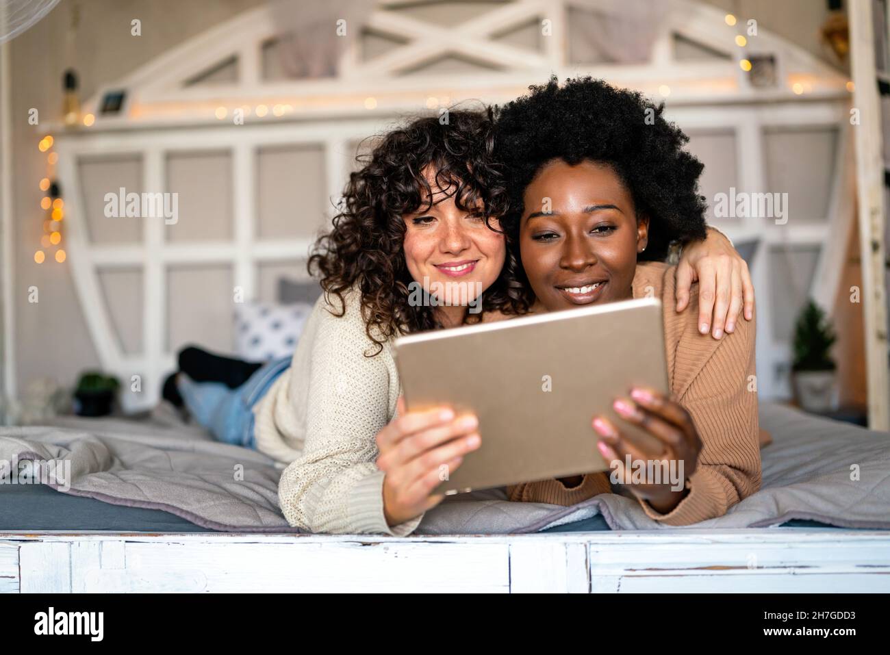 Beautiful happy gay couple having fun and good time together with tablet at home Stock Photo