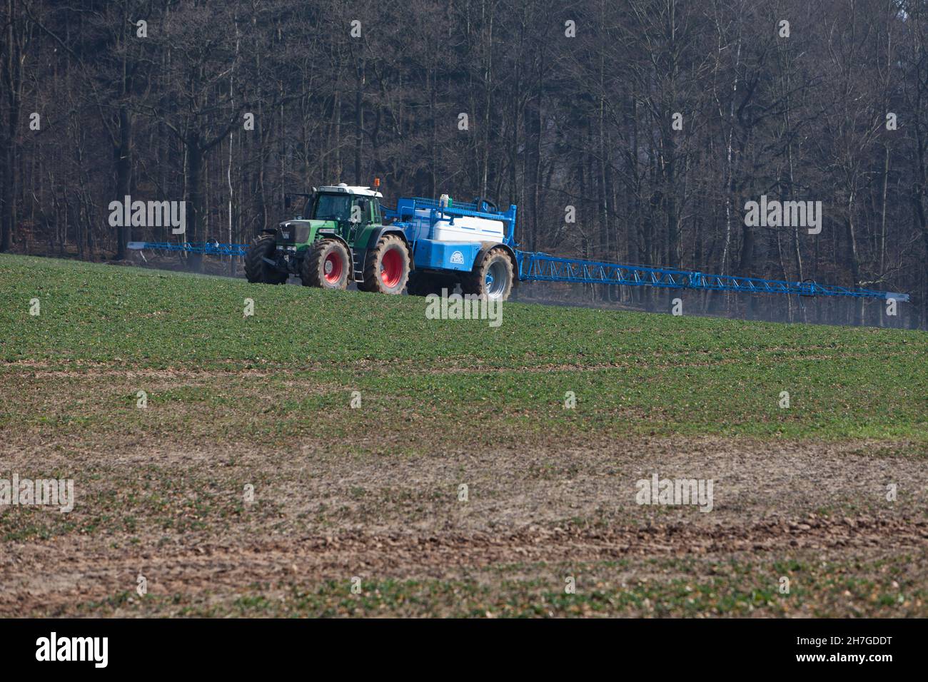 Chemical spraying pesticide on crop, in springtime, Lower Saxony, Germany, Stock Photo
