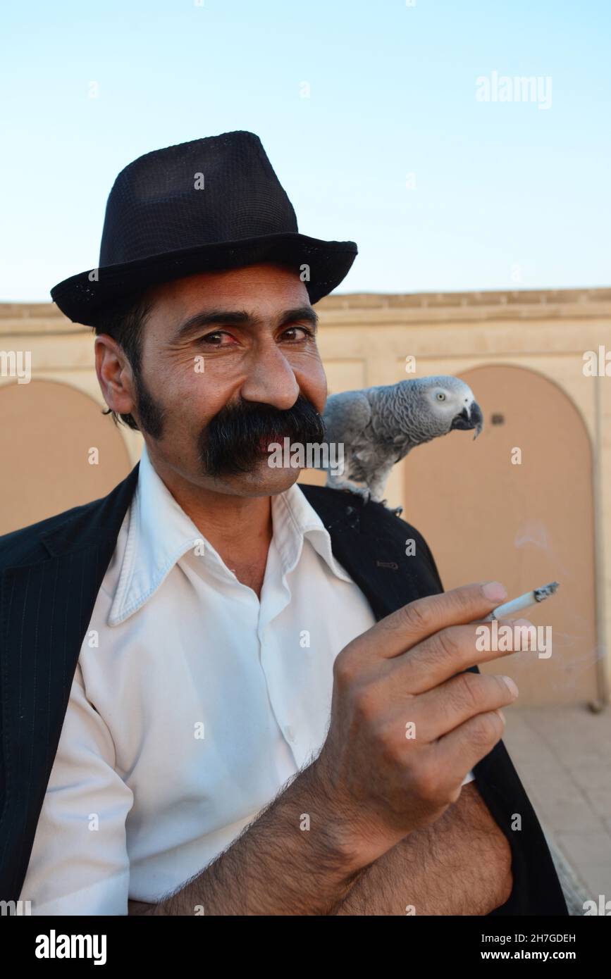 IRAN. YAZD. PORTRAIT OF A MAN WITH A PARROT. Stock Photo