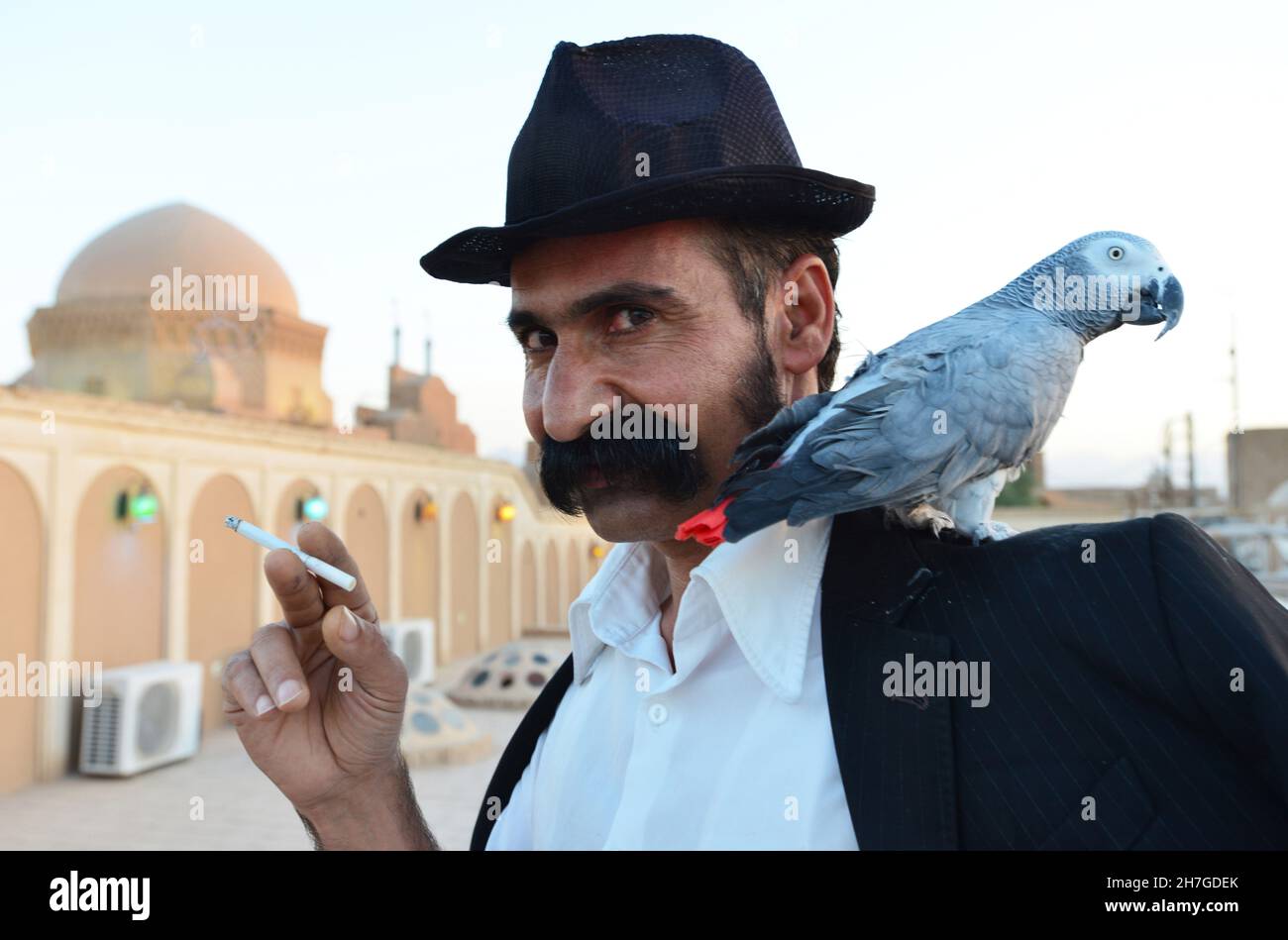 IRAN. YAZD. PORTRAIT OF A MAN WITH A PARROT. Stock Photo