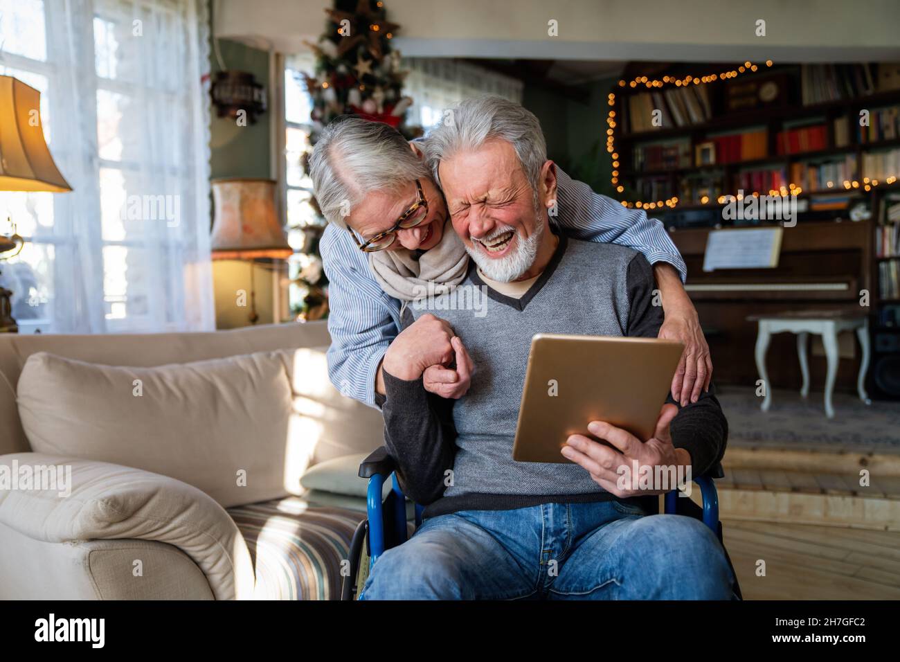 Senior couple having fun and laughing while using their tablet pc computer. Stock Photo