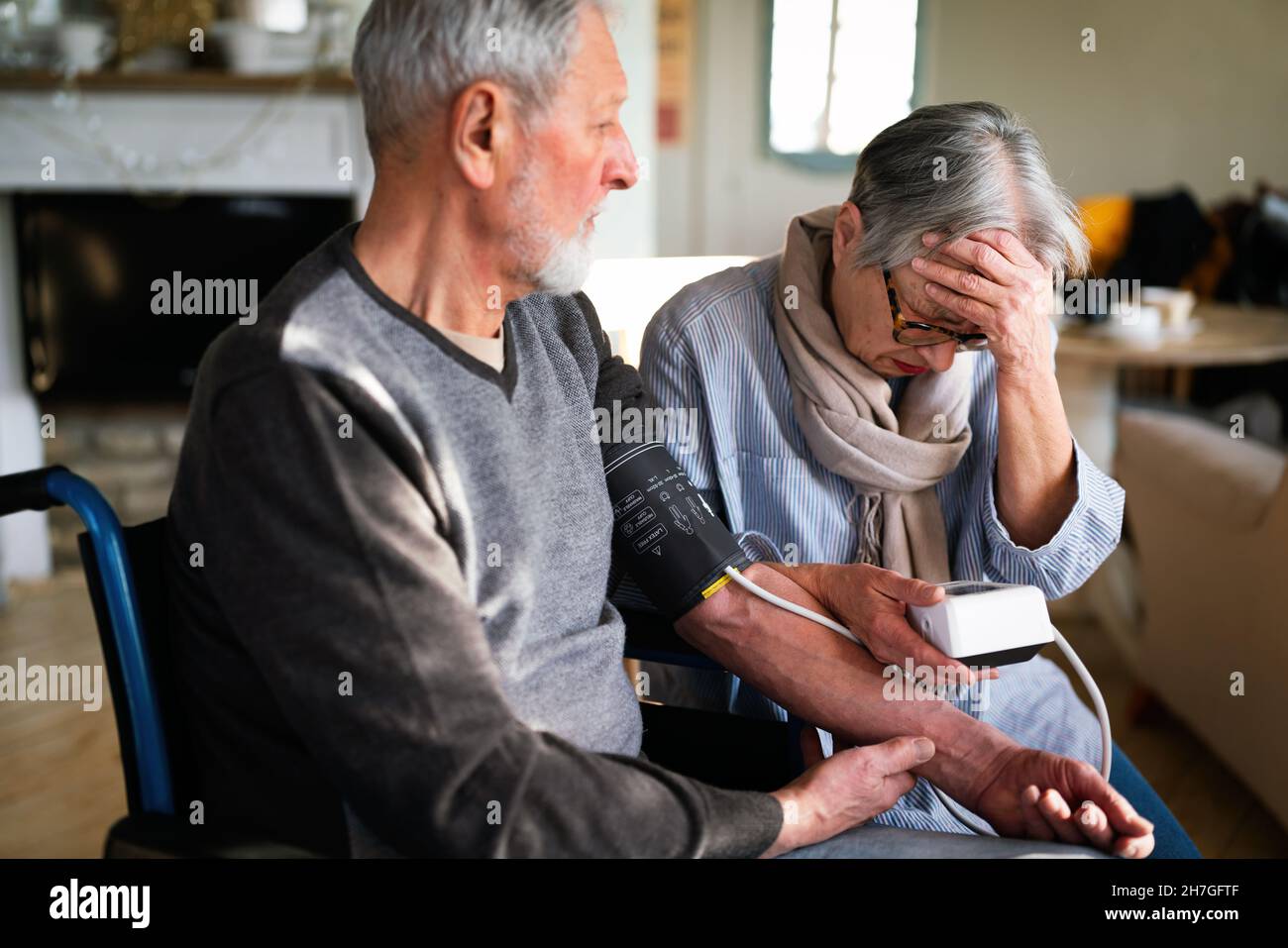 Senior couple at home measuring blood pressure. Home monitoring people healthcare concept Stock Photo