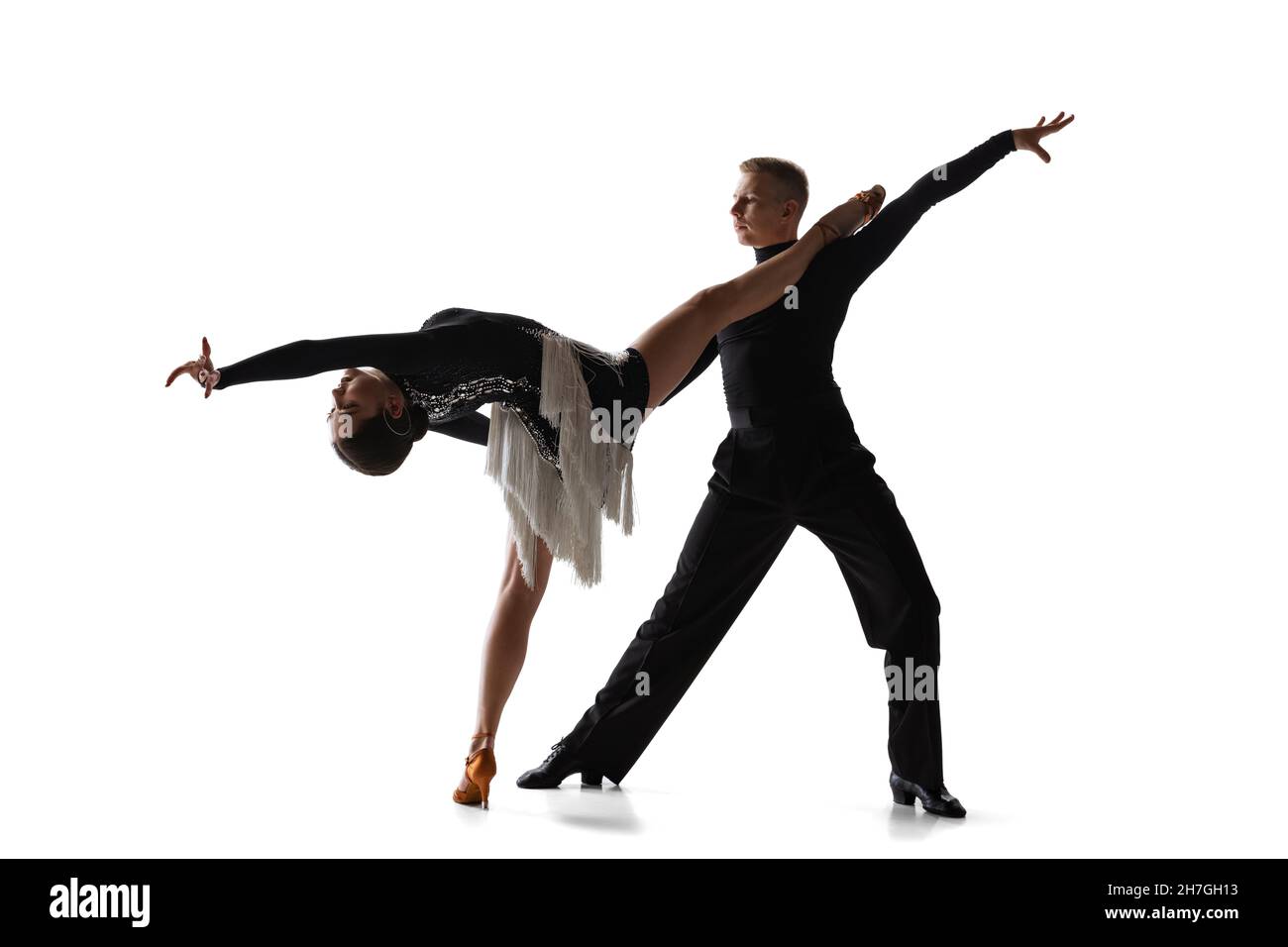 Two young graceful dancers, flexible man and woman dancing ballroom dance isolated on white studio background. Stock Photo