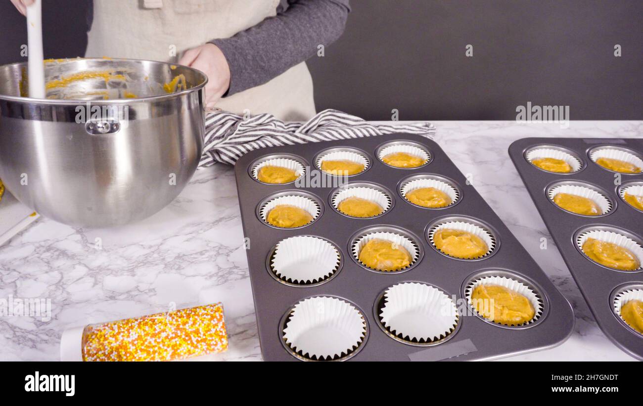 Scooping pumpkin spice cupcake batter with batter scoop into a cupcake