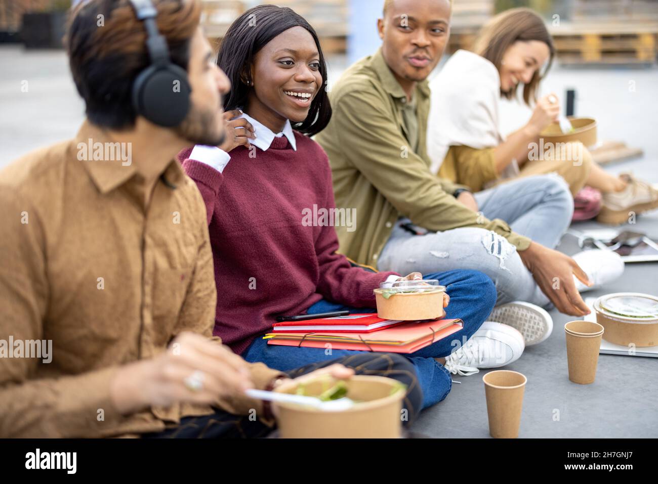 Students eating salad during lunch on asphalt Stock Photo