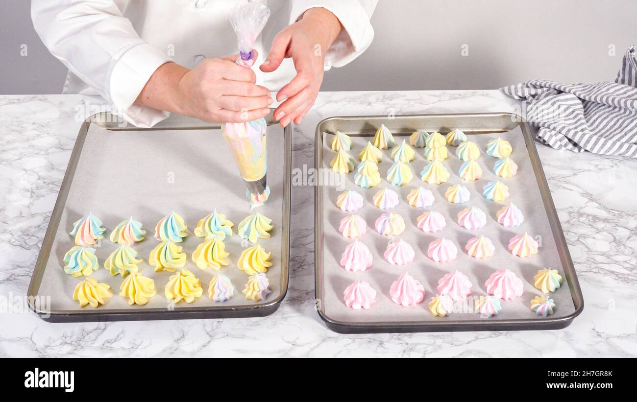 Step by step. Piping unicorn meringue cookies to the baking sheet lined