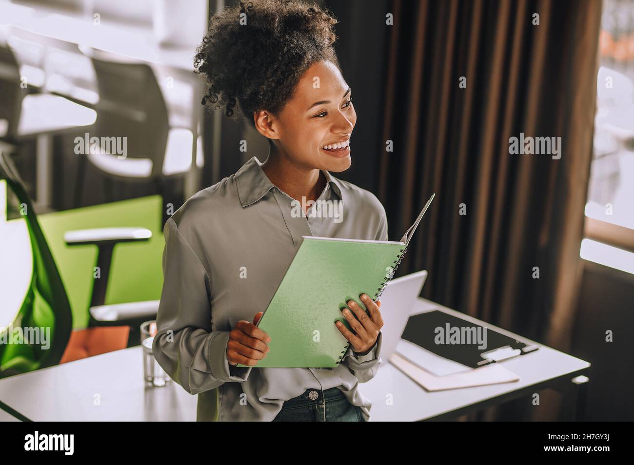 Young curly-haired woman scrutinizing the project papers Stock Photo
