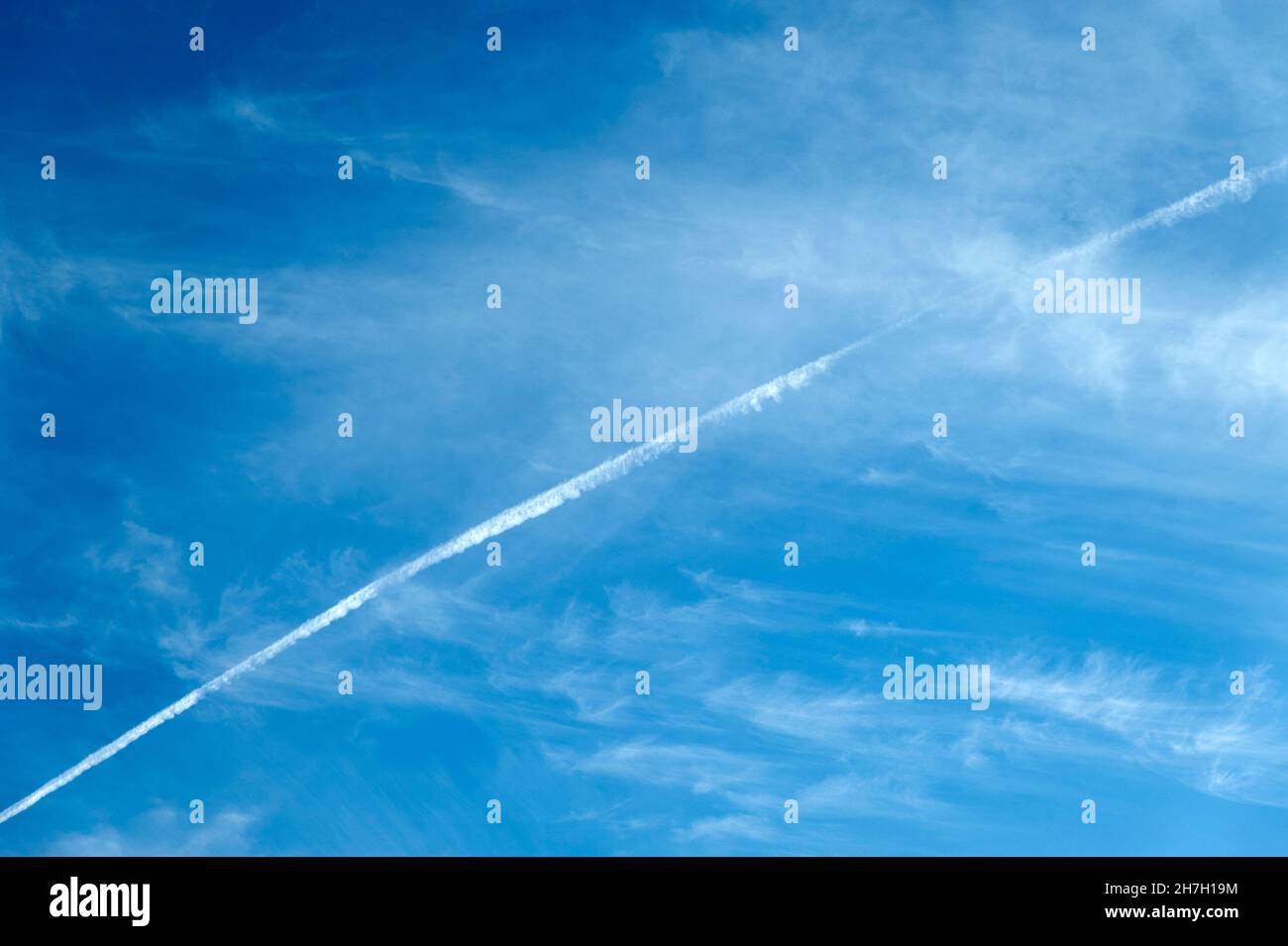 Airplane smoke in cloudy blue sky.Stock photo. Stock Photo
