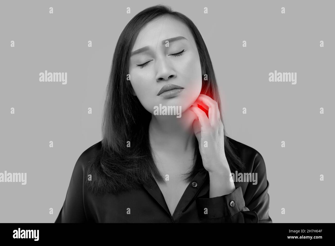 Asian woman scratched her neck on a gray background. Stock Photo