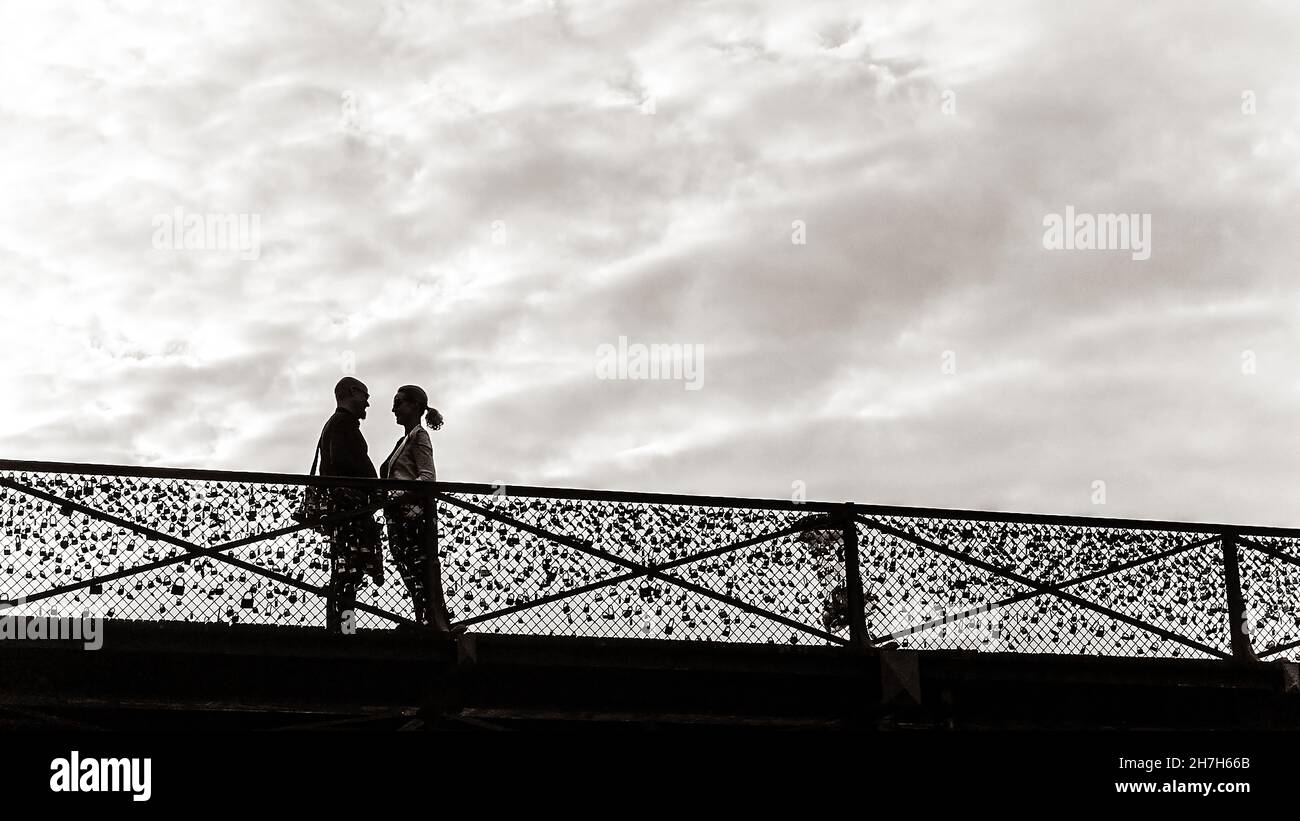 Couple standing on a bridge under a cloudy sky Stock Photo - Alamy