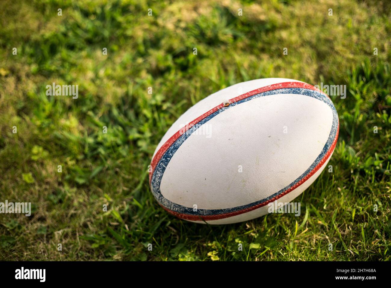 Rugby  ball , Gilbert ,on sports field with green grass for the game of rugby. Focus on ball, sports base at background. Stock Photo