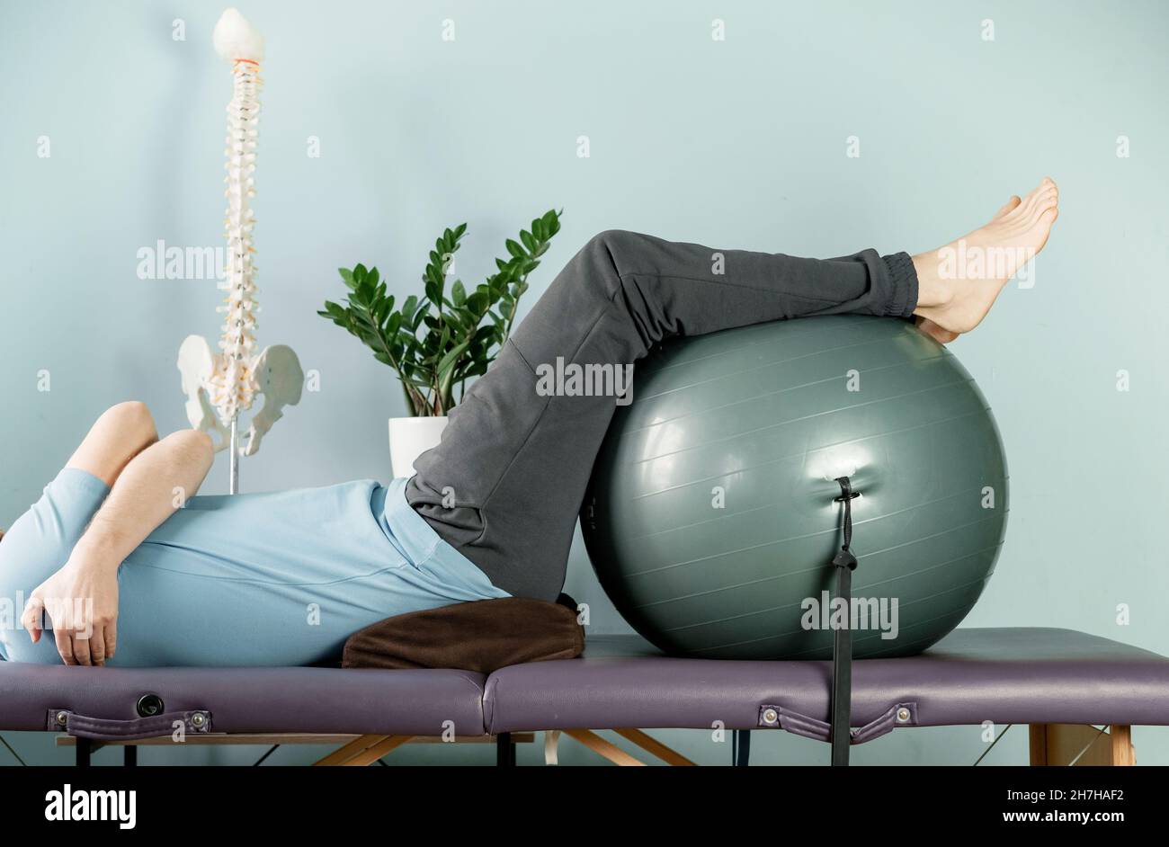 A man lying on the massage table in constructive rest postion, si joint