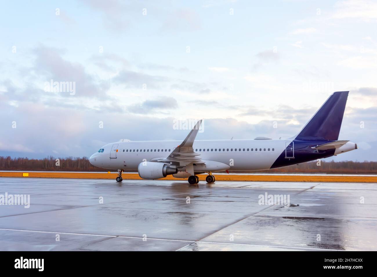 Jet plane rides on wet asphalt after landing Stock Photo - Alamy