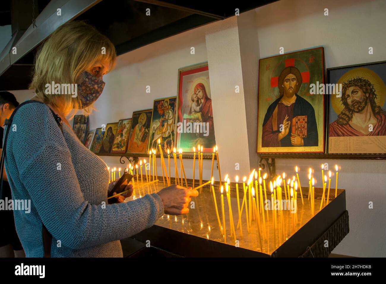woman lighting a candle in an orthodox church,Bulgaria,Europe Stock