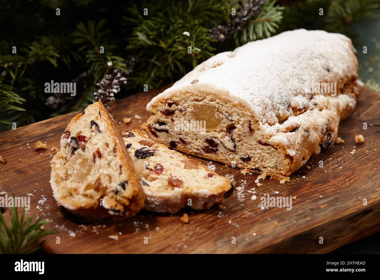Sliced Christmas stollen cake on wooden board Stock Photo