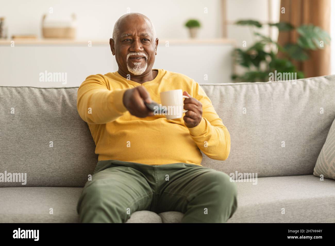 Senior African American Man Watching TV Switching Channels At Home Stock Photo