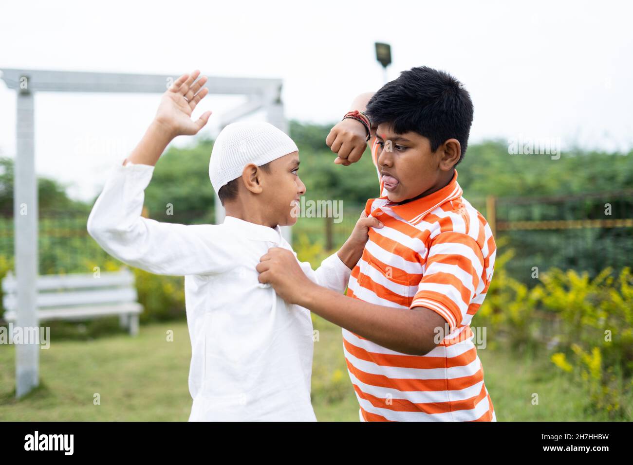 Indian multiethnic kids fighting while playing at park - concept showing of children quarrel, communal violence, conflict or clash. Stock Photo