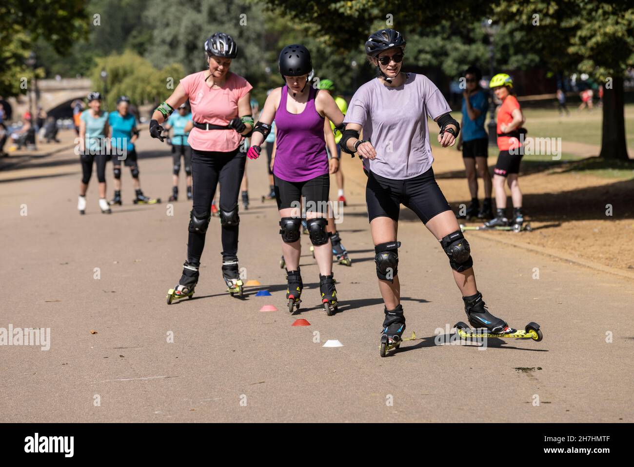 Group of people learning to roller-ski in Hyde Park, London, England UK Stock Photo