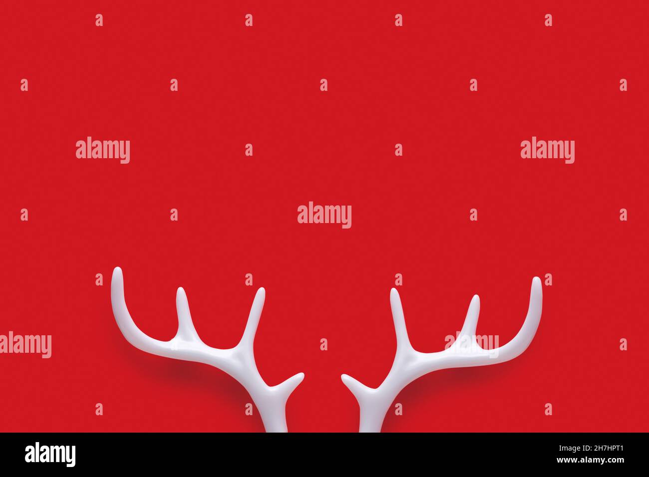 White Christmas reindeer antlers on red background. Minimal New Year or Christmas concept. Flat lay. Stock Photo