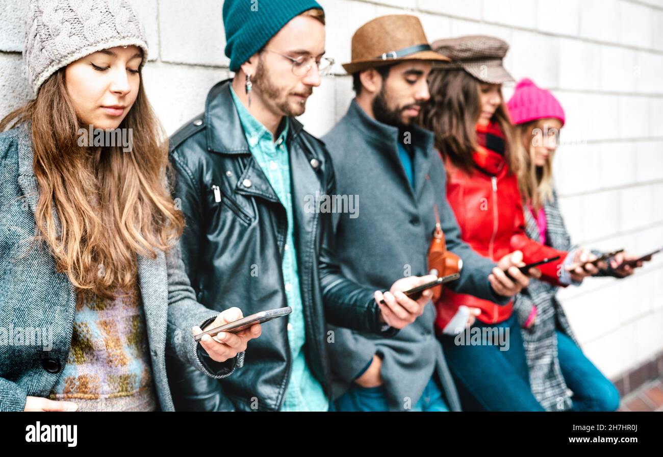 Side view of milenial guys and girls using mobile smartphone - People addicted by smart phone - Life style concept with always connected teenagers Stock Photo