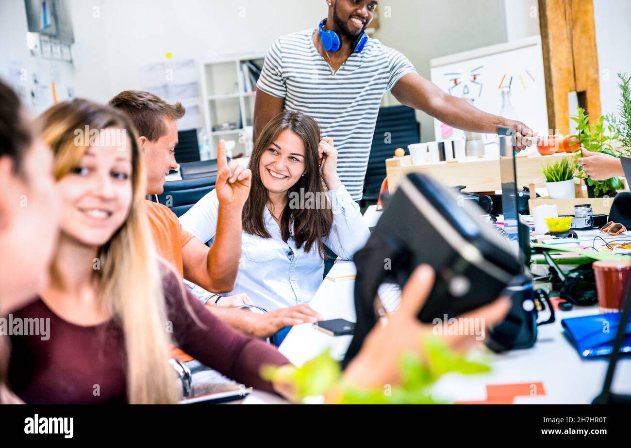Group of young people employee workers having fun with vr virtual reality goggles in urban alternative studio - Business concept of human resource Stock Photo