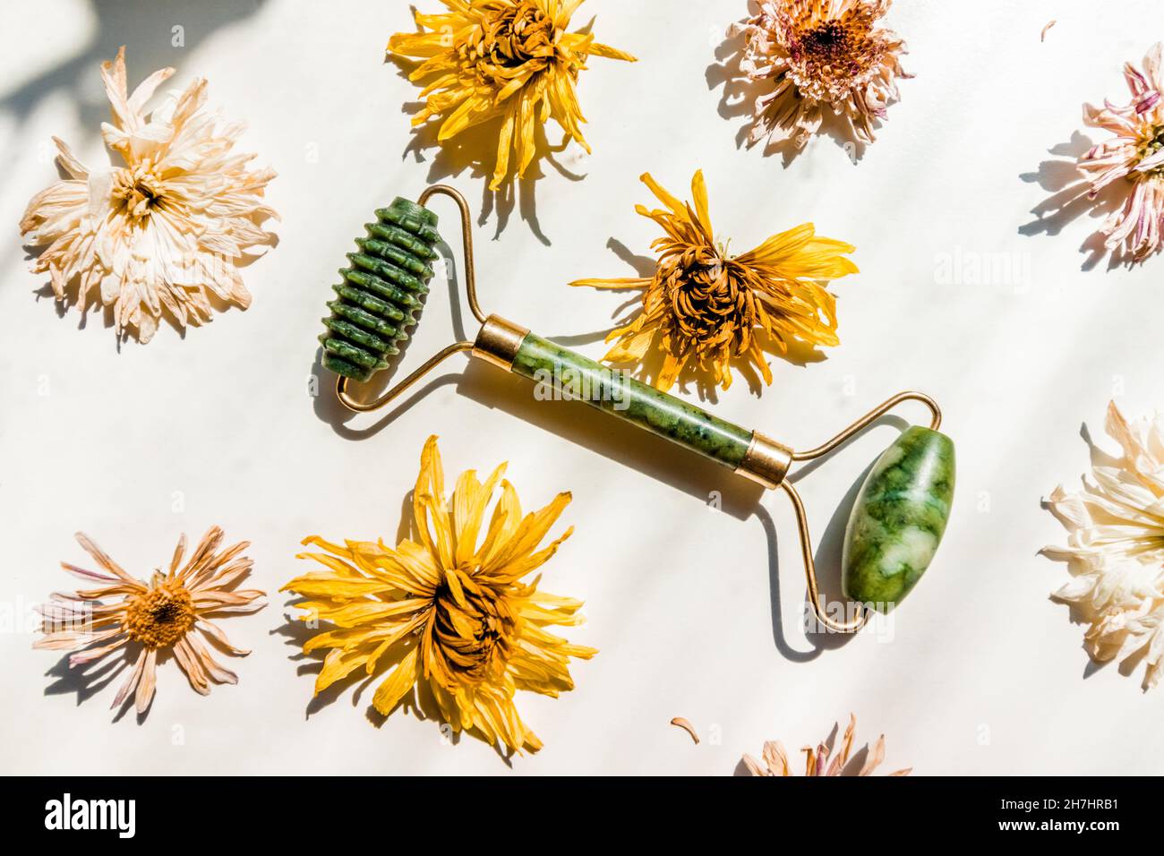 Green jade massager roller for the face on a white background. Stock Photo