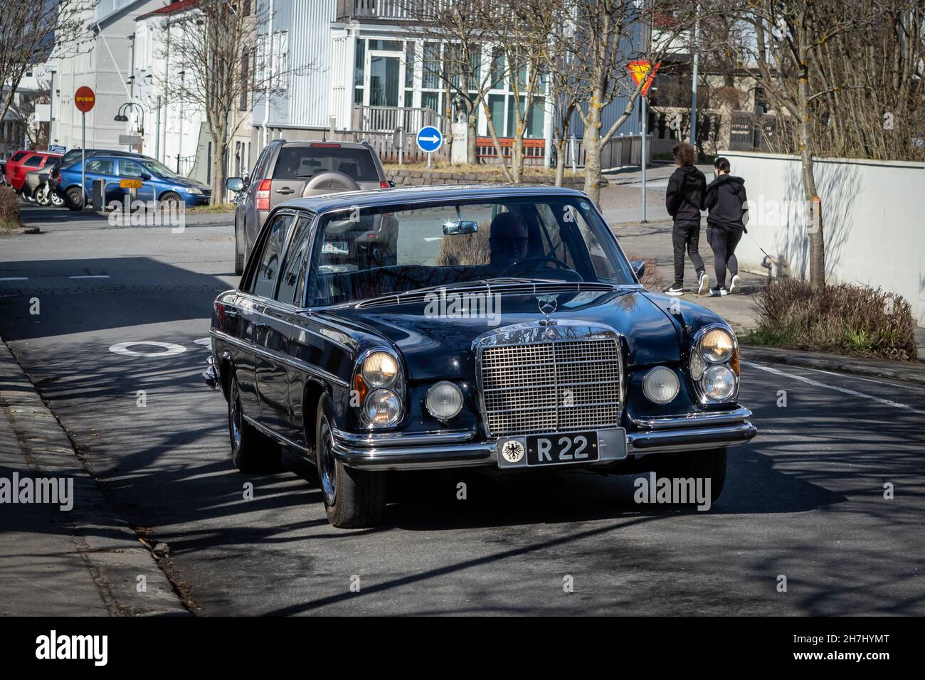 Reykjavik, Iceland - June 12 2021: A black Mercedes W108/109 driving on the street in Reykjavik downtown. People walking by, sunny day. Stock Photo