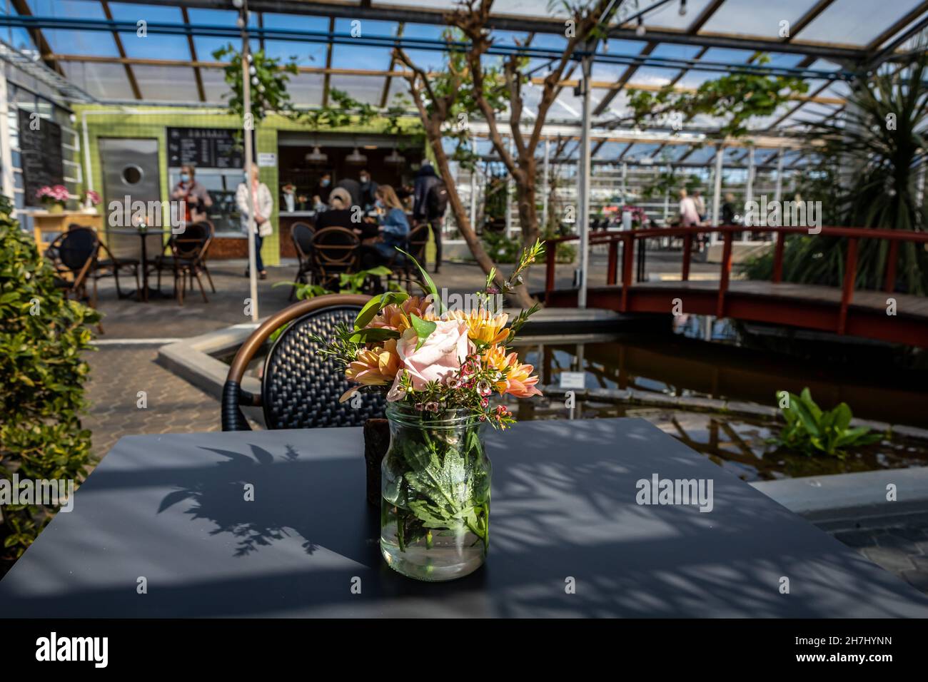 Reykjavik, Iceland - April 26, 2021: Florian Cafe greenhouse bar in Reykjavik's botanical garden. A glass vase with flowers on the table with an empty Stock Photo