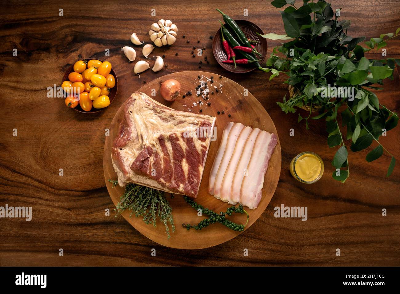 smoked fatty bacon on rustic wood table with natural ingredients arrangement Stock Photo