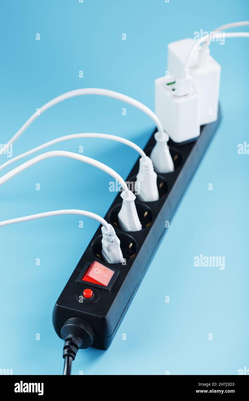 Surge protector with connected white wires of electrical appliances on a blue background. Free