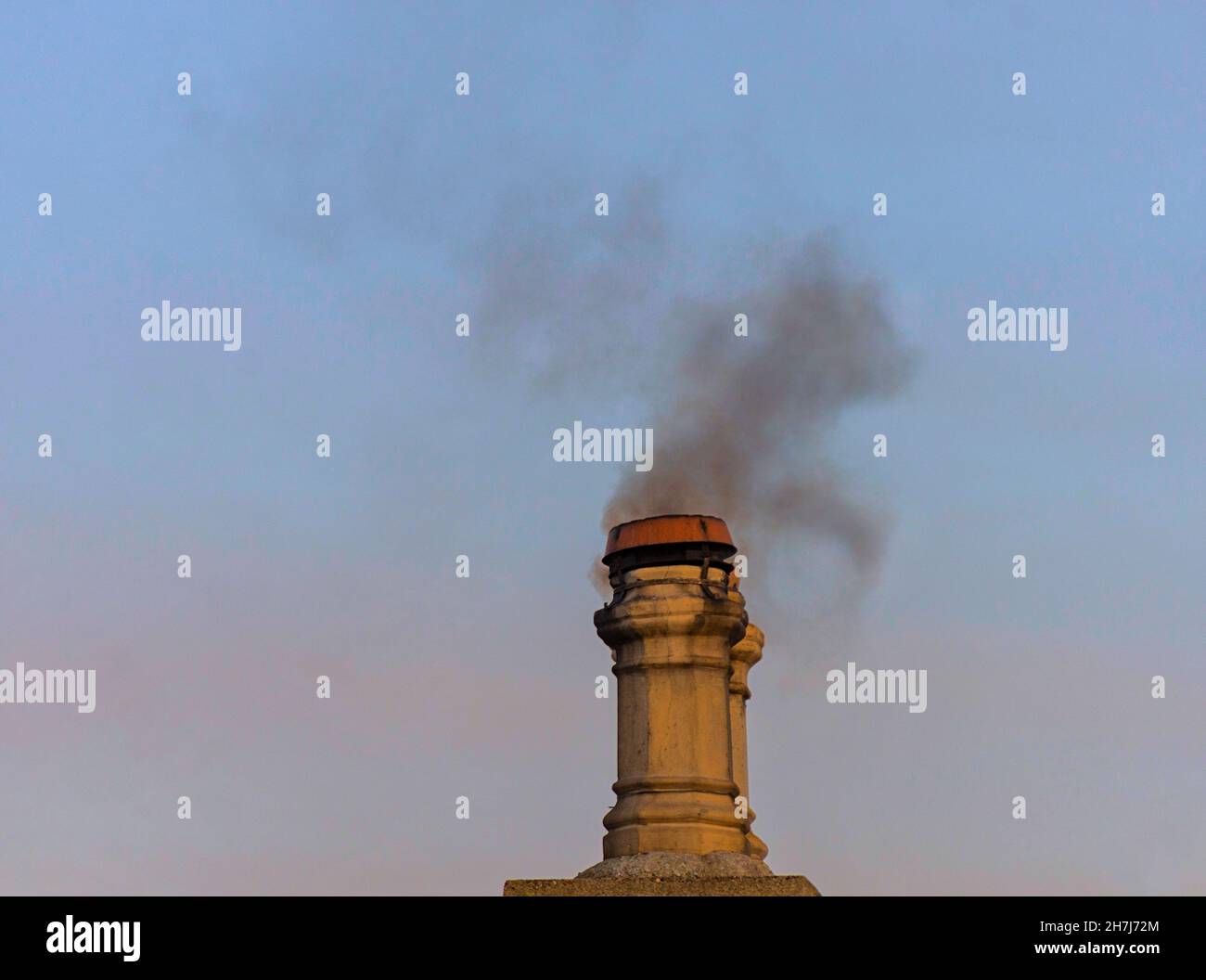 SMOKE FROM CHIMNEY OF A WOOD BURNER DETRIMENTAL ATMOSPHERIC POLLUTION Stock Photo