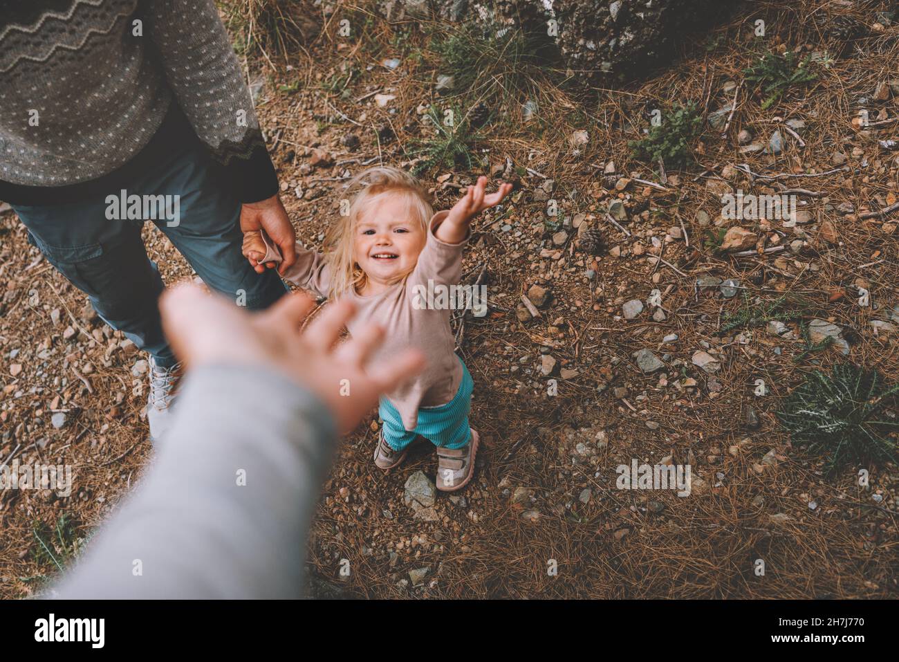 Family child with father and mother walking outdoor holding hands vacations together Stock Photo
