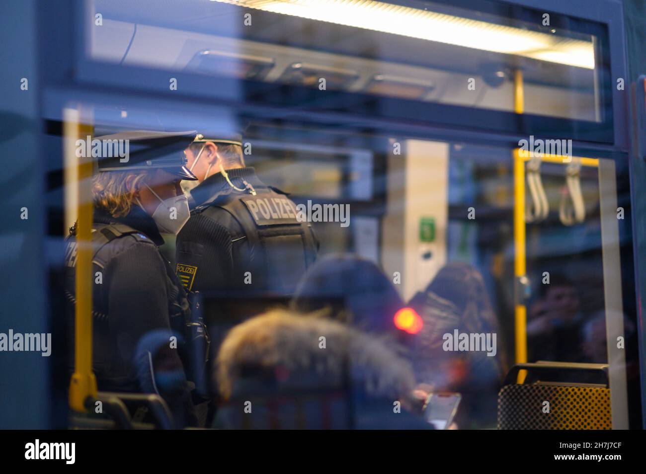 Dresden, Germany. 23rd Nov, 2021. Police officers ride in a DVB tram in Dresden city centre. The Dresden police department is monitoring compliance with the new Corona rules on a daily basis with 50 officers. Accordingly, the focus is on controls of the FFP2 mask obligation in public transport as well as the exit restrictions for unvaccinated persons in hotspot areas. Credit: Robert Michael/dpa-Zentralbild/dpa/Alamy Live News Stock Photo