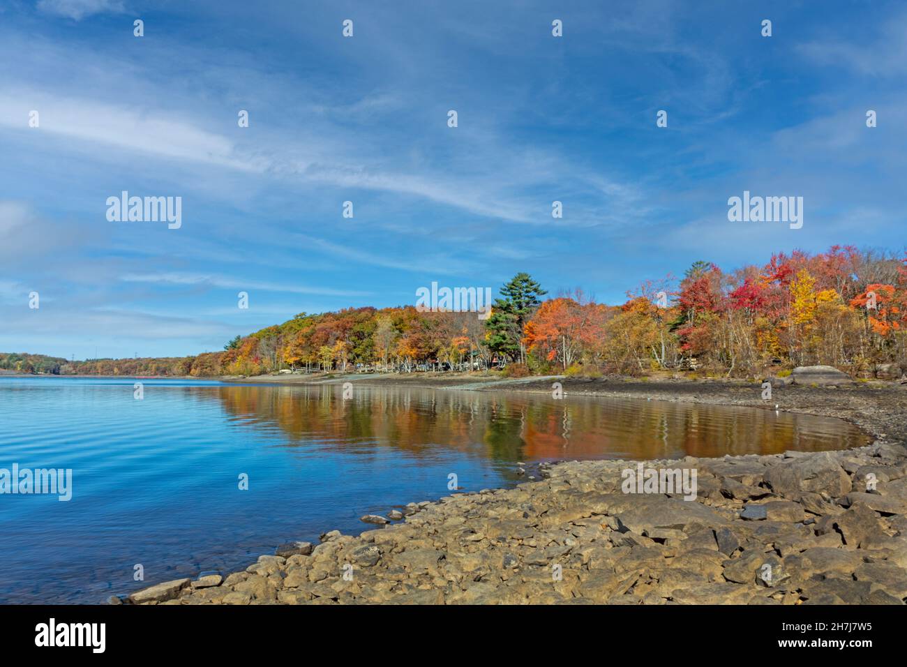 Lake Wallenpaupack in Poconos PA on a bright fall day lined with trees in vivid and beautiful foliage Stock Photo