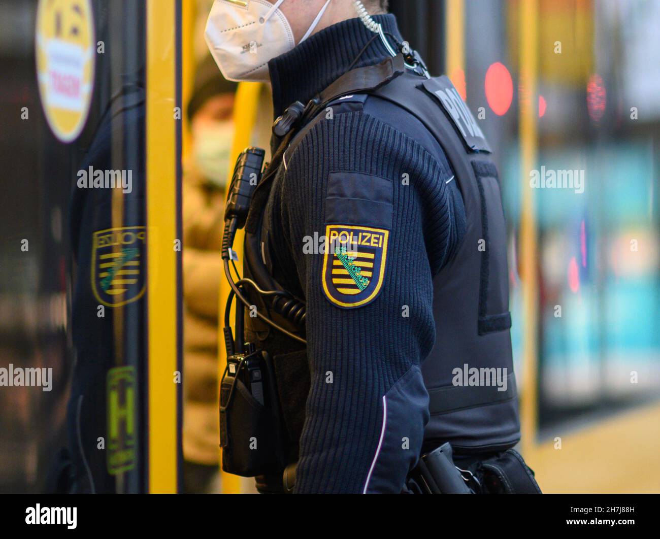 Dresden, Germany. 23rd Nov, 2021. A police officer boards a DVB tram in Dresden city centre. The Dresden police department is monitoring compliance with the new Corona rules on a daily basis with 50 officers. Accordingly, the focus is on controls of the FFP2 mask obligation in public transport as well as the exit restrictions for unvaccinated persons in hotspot areas. Credit: Robert Michael/dpa-Zentralbild/dpa/Alamy Live News Stock Photo