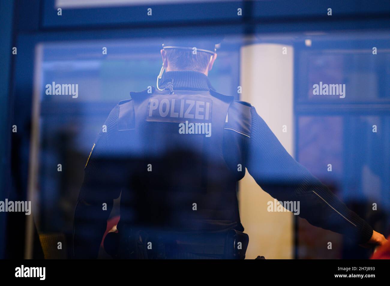 Dresden, Germany. 23rd Nov, 2021. A policeman stands in a DVB tram in Dresden city centre. The Dresden police department is monitoring compliance with the new Corona rules on a daily basis with 50 officers. Accordingly, the focus is on controls of the FFP2 mask obligation in public transport as well as the exit restrictions for unvaccinated persons in hotspot areas. Credit: Robert Michael/dpa-Zentralbild/dpa/Alamy Live News Stock Photo